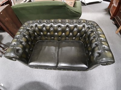 Lot 411 - A modern two-seater leather settee in the Chesterfield style