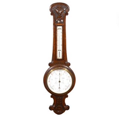 Lot 521 - An Edwardian carved oak aneroid wall barometer