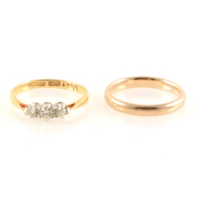 Lot 343 - A diamond three stone ring and 9 carat yellow gold wedding band.