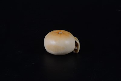 Lot 38 - A Japanese carved and stained ivory model of a part-peeled satsuma, early 20th Century