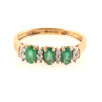 Lot 336 - An emerald and diamond half hoop ring.