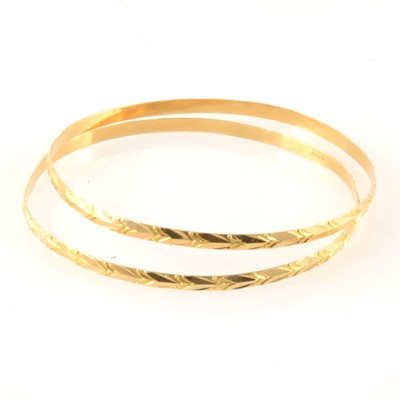 Lot 378 - Two yellow metal slave bangles stamped "18ct"