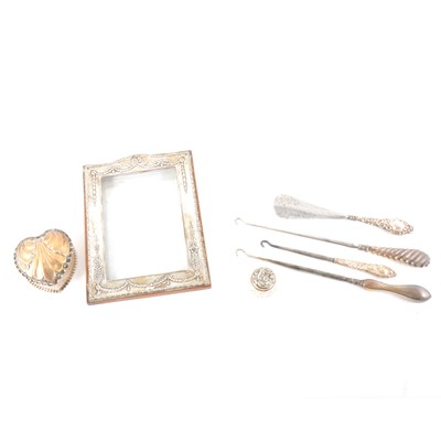 Lot 320 - A silver photograph frame, heart shaped trinket box, button hooks, thimbles.