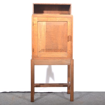 Lot 193 - A small Arts & Crafts oak cabinet on stand.