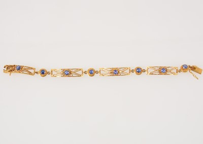 Lot 325 - A yellow metal bracelet having four rectangular pierced links each set with an untested blue stone