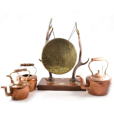 Lot 139 - Three copper kettles, and a brass dinner gong, on antler formed frame.