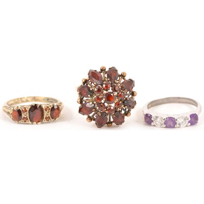 Lot 184 - Two garnet dress rings and an amethyst ring.