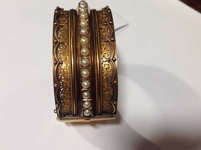 Lot 212 - A Victorian yellow metal half hinged bangle set with pearls.