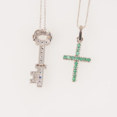 Lot 335 - An emerald cross and chain and a sapphire key pendant.