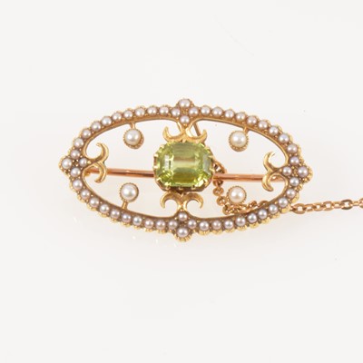 Lot 333 - A green peridot and seed pearl brooch set in a yellow metal oval frame setting, 30mm x 17mm.