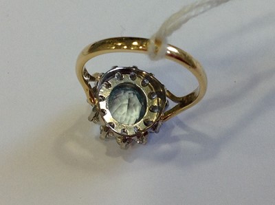 Lot 205 - An aquamarine and diamond oval cluster ring.