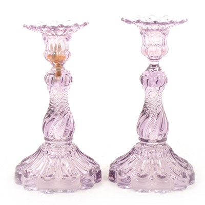 Lot 7 - A pair of amethyst-coloured moulded glass candlesticks.