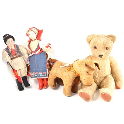 Lot 25 - A vintage 1950s straw filled teddy bear, 49cm tall, a straw filled dog, and two character dolls.