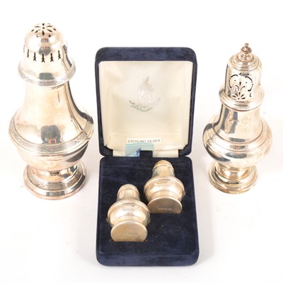 Lot 97 - A pair of silver salt and pepper shakers, a silver sugar caster, and a silver-plated sugar caster.