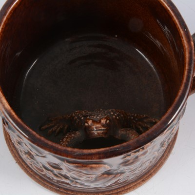 Lot 27 - Staffordshire treacle-glazed frog mug and pair of Bacchus mask Loving Cups.