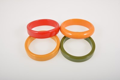 Lot 375 - Four vintage coloured bakelite solid bangles.