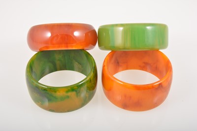 Lot 381 - Four vintage coloured bakelite solid bangles