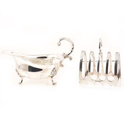Lot 215 - A silver sauce boat by Jenkins & Timm, Sheffield 1922 and silver toast rack.