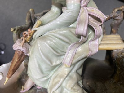 Lot 17 - A Continental porcelain centrepiece of a lady seated on a bench