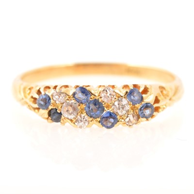 Lot 193 - A diamond and blue stone half hoop dress ring.