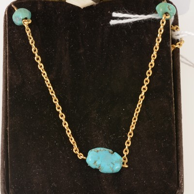 Lot 204 - Yellow metal necklace with seven turquoise matrix beads.