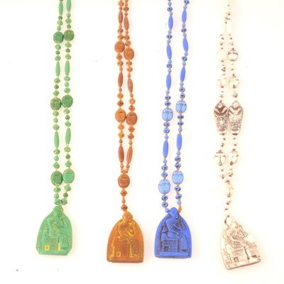 Lot 243 - Four Egyptian Revival pressed glass scarab bead sautoir necklaces.