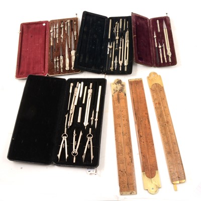 Lot 159 - A quantity of cased drawing instruments, folding yardsticks and rules.