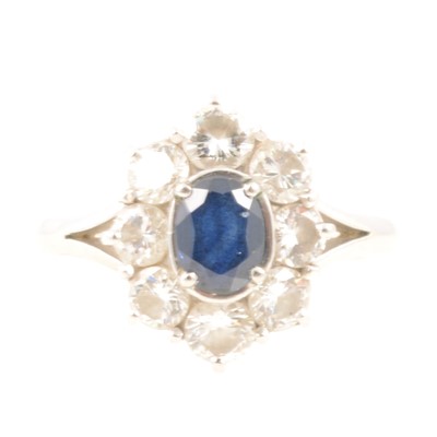 Lot 235 - Sapphire and diamond oval cluster ring.