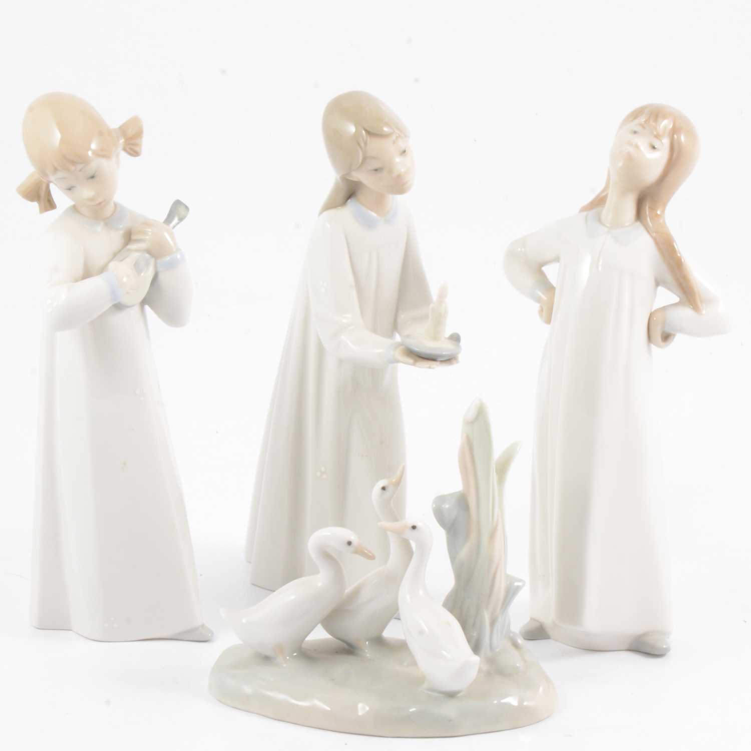 Lot 28 - Three Lladro figures and a Nao group of geese.