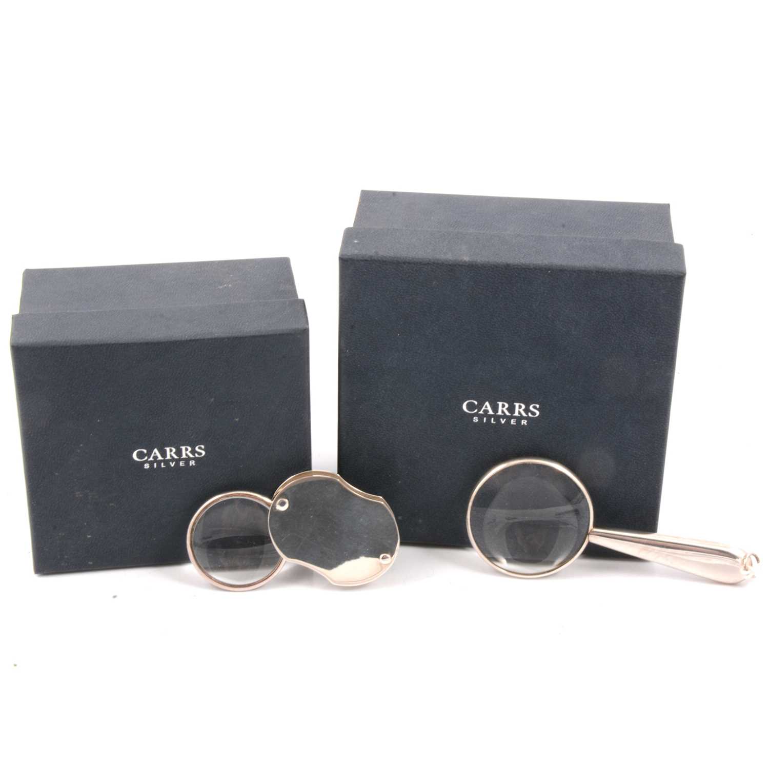 Lot 191 - A silver folding loop/eyeglass and a small silver coloured magnifying glass, both new and boxed.