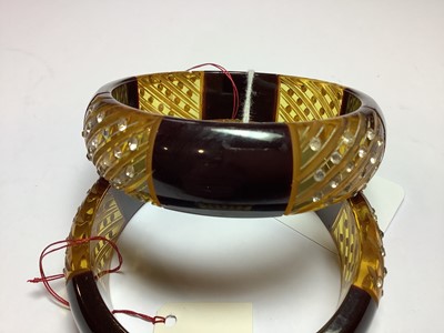 Lot 286 - Pair of vintage bakelite and lucite bangles set with clear paste.