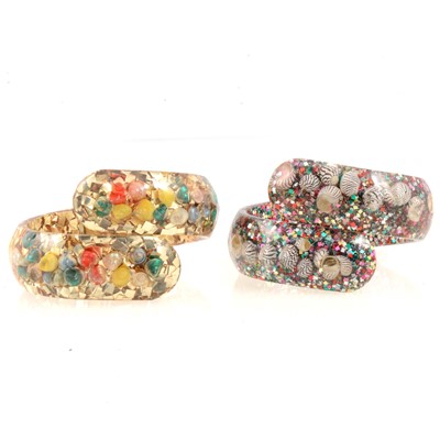 Lot 284 - Two vintage confetti lucite clamper bracelets decorated with seashells.