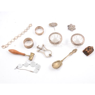 Lot 285 - Silver napkin rings, French skirt lifter, netsuke, powder measure, coin jewellery.