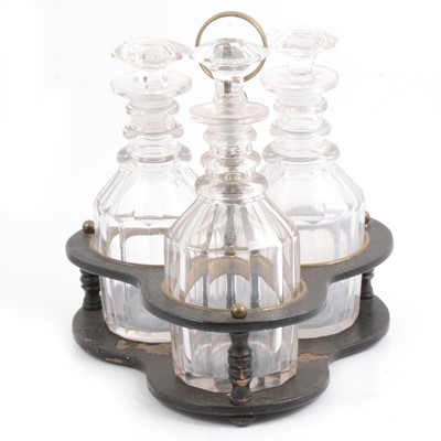 Lot 168 - Georgian trefoil lacquered wooden and brass bottle stand with three matched cut-glass decanters.