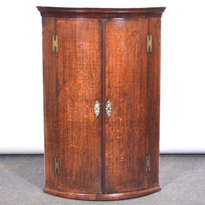 Lot 435 - George III oak bowfront hanging corner cupboard