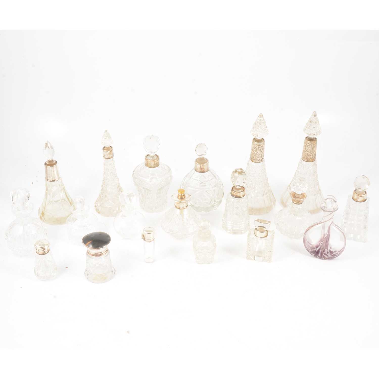 Lot 146 - Eighteen cut glass scent bottles and one dressing table pot, many with silver collars.