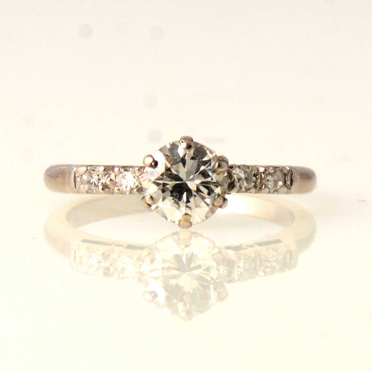Lot 58 - A diamond solitaire ring with diamond shoulders.