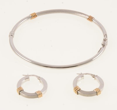 Lot 315 - A 9 carat white gold bangle and matching earrings.