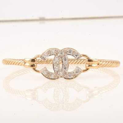 Lot 353 - A 9 carat yellow gold bangle, double C Chanel motif.