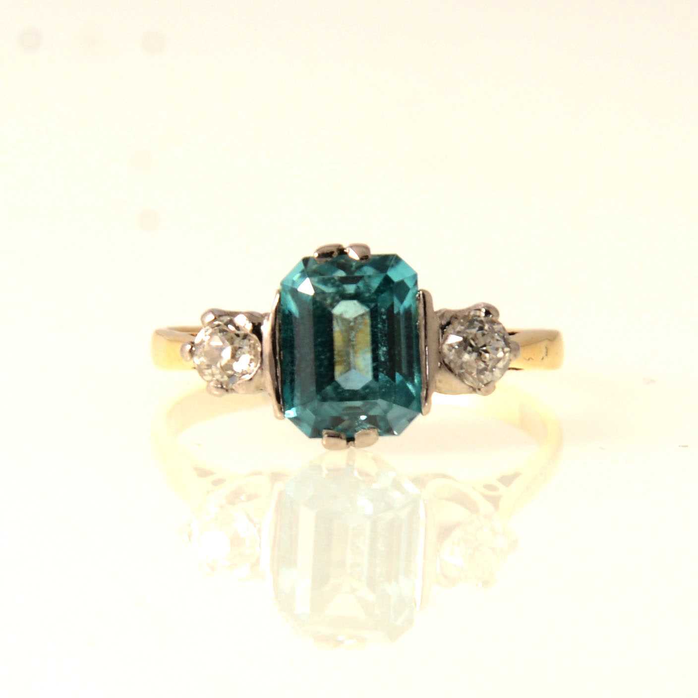 Lot 75 - A three stone ring with diamonds and aqua coloured stone.