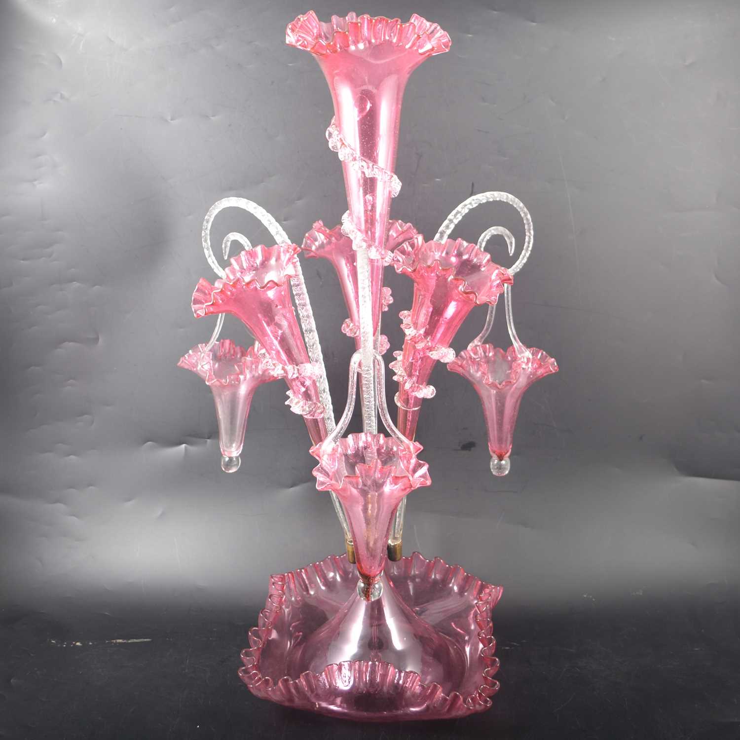 Lot 6 - A cranberry glass epergne, central flute with three surrounding.