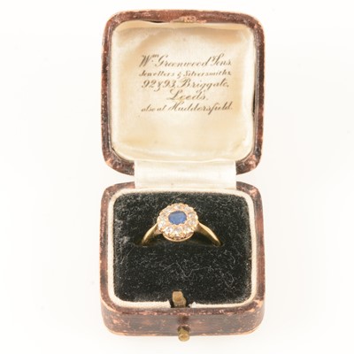 Lot 296 - A sapphire and diamond cluster ring.
