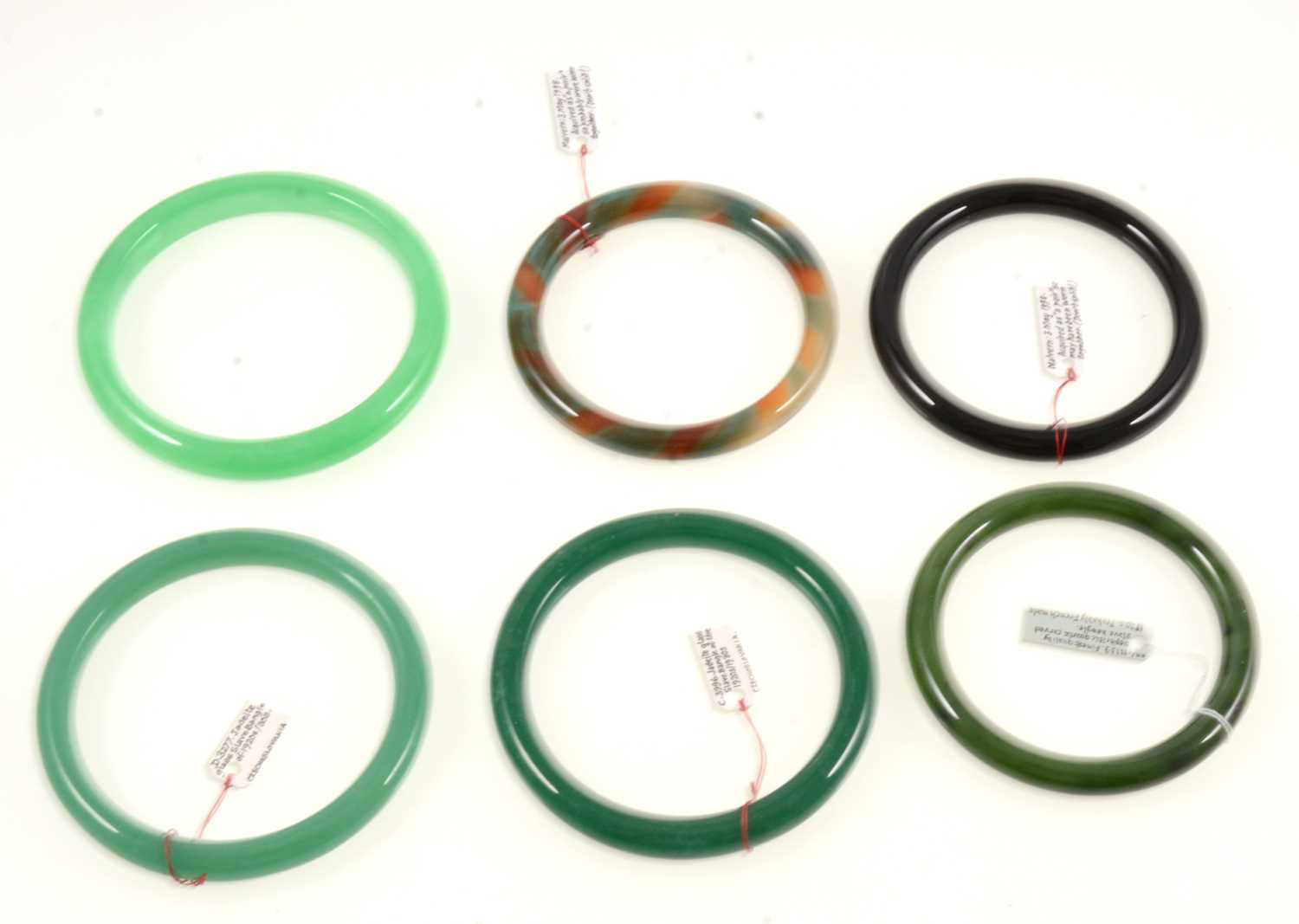 Lot 374 - Six jadeite glass and simulated agate slave bangles.