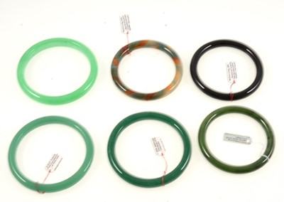 Lot 374 - Six jadeite glass and simulated agate slave bangles.