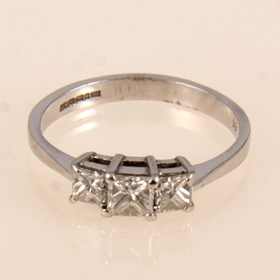 Lot 230 - A princess cut diamond three stone ring.