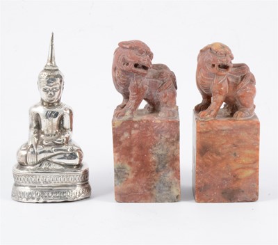 Lot 103 - Two carved red stone scroll weights and a white metal Eastern figure of Buddha