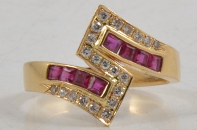Lot 266 - A ruby and diamond crossover ring.