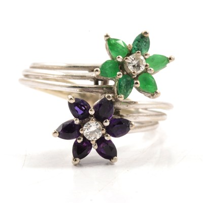 Lot 313 - An emerald and amethyst dress ring.