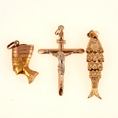 Lot 263 - Three gold pendants, fish, crucifix and Nefertiti.