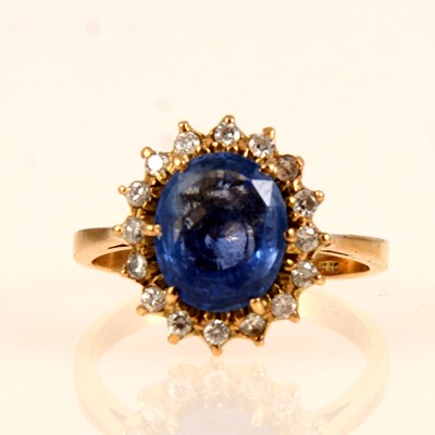 Lot 245 - A sapphire and diamond oval cluster ring.